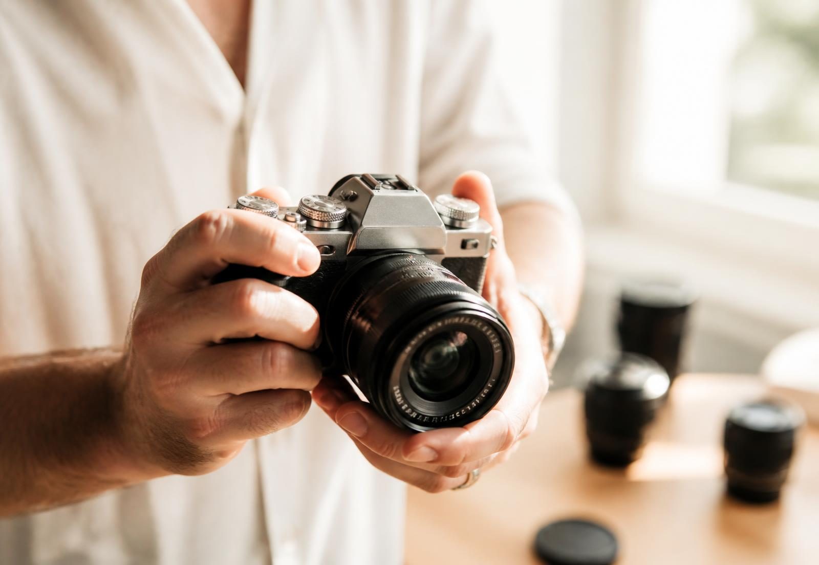 Fotografo con fotocamera mirrorless e obiettivi